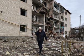 In this photo provided by Ukraine's 65th Mechanized Brigade press service, a local passes by a destroyed apartment building following an Russian air strike in the town of Komyshuvakha in the Zaporizhzhia region of Ukraine on 20 February.
